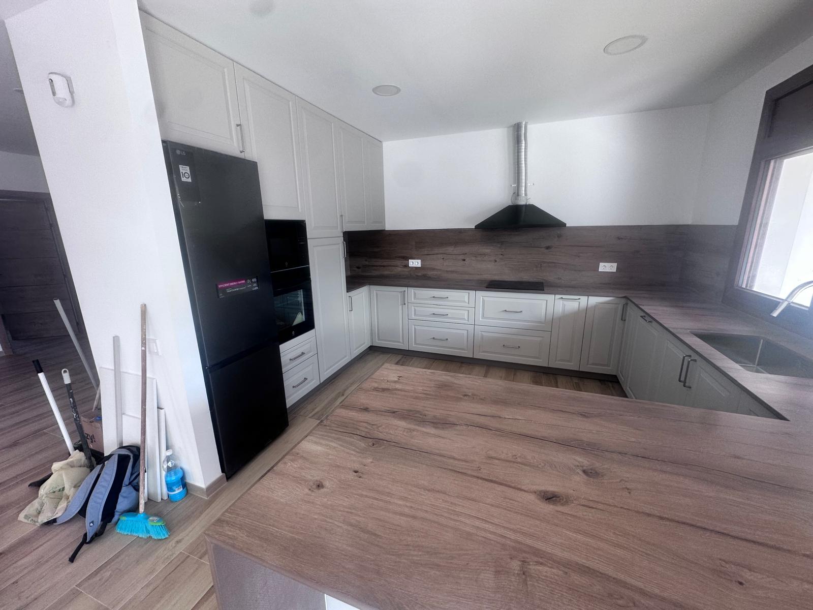 Otra vista de una cocina reformada con zona de trabajo y suelos nuevos